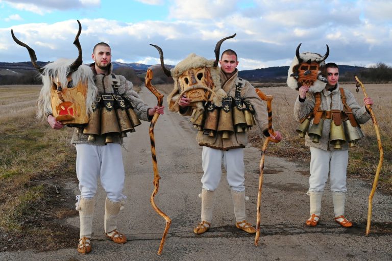 Group of Kukeri with mask in hands at sunset in Bulgaria