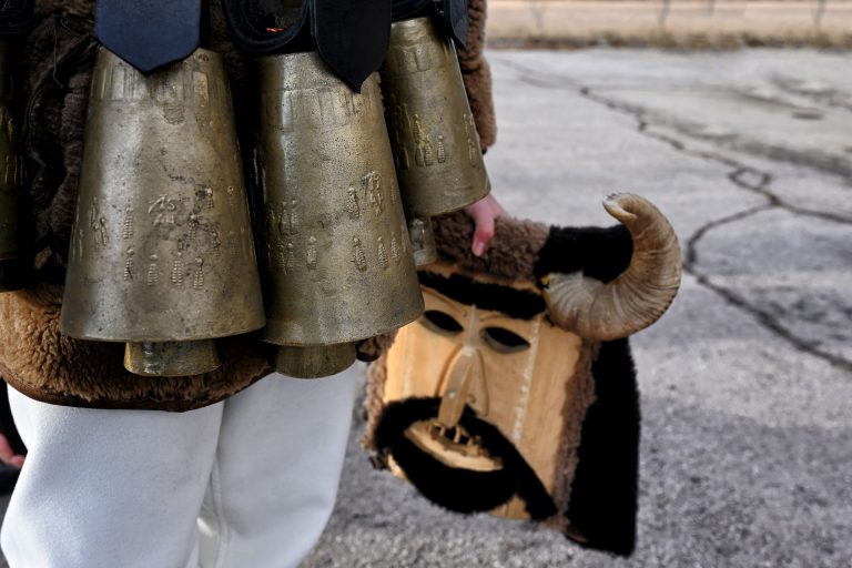 Detailed photo of kuker with bells and mask in hand