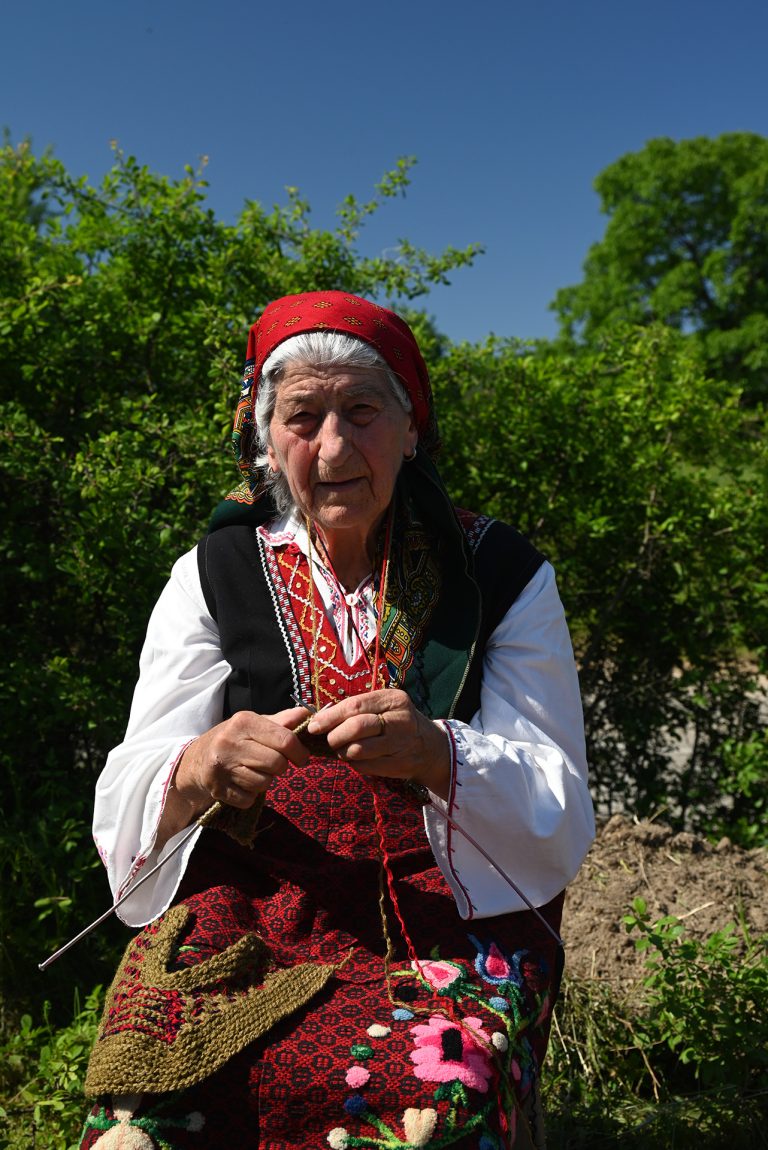 Old lady knitting on field in Bulgaria