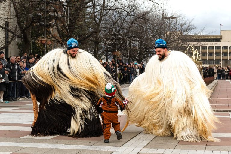 babugeri kukeri dancing with a little child at a kukeri festival in Bulgaria